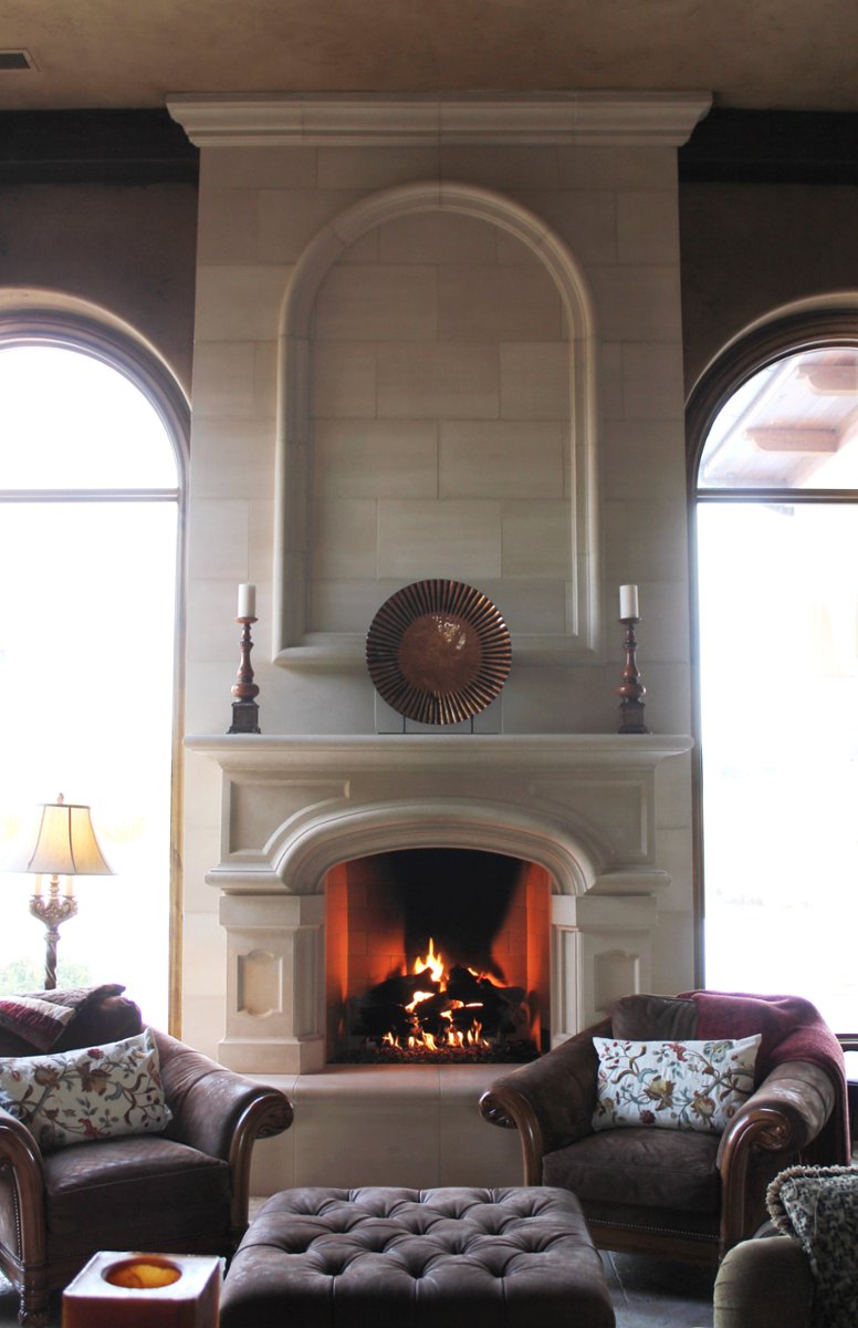 An elegant cast stone fire surround with a tall overmantel, manufactured and installed by 